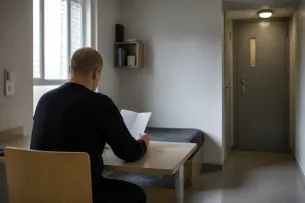 Intagen läser information vid ett bord i ett svenskt bostadsrum