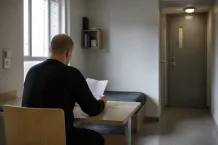 Intagen läser information vid ett bord i ett svenskt bostadsrum
